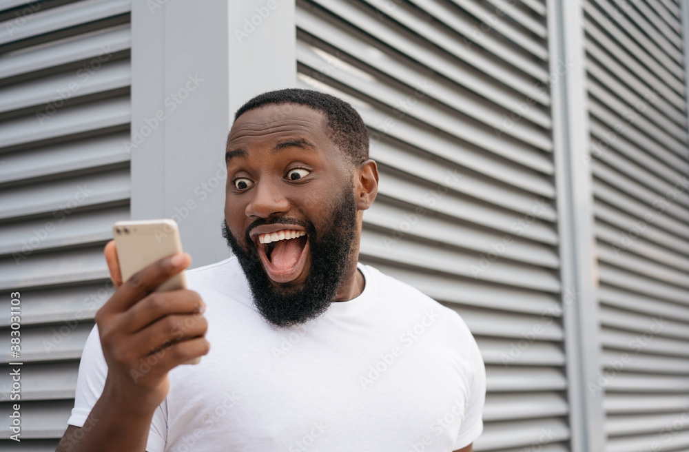 Ταπετσαρία Excited African American man using mobile phone, shopping online on Black Friday