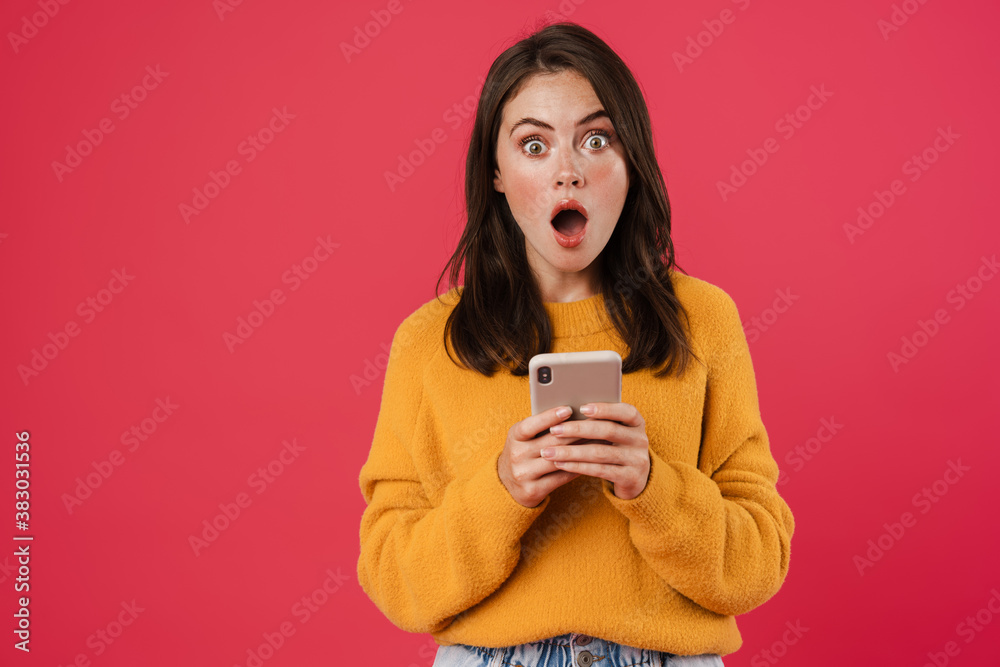 Image of shocked brunette girl posing and using mobile phone Image of shocked brunette girl posing and using mobile phone