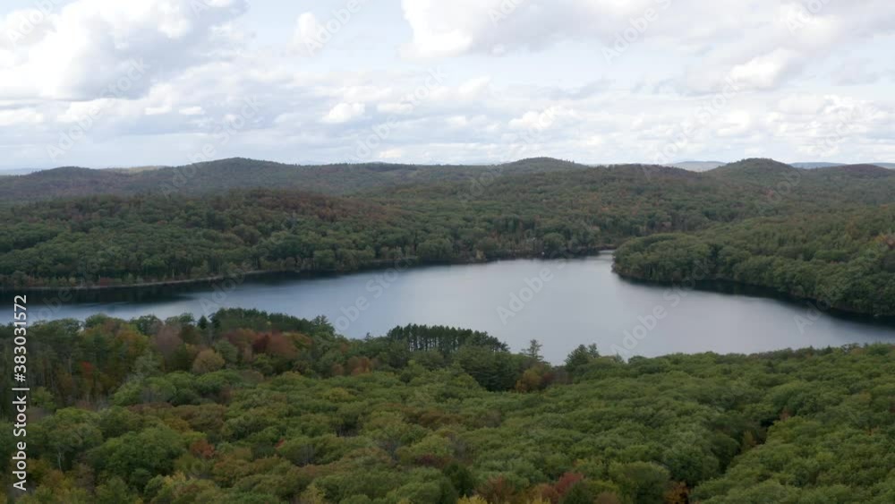 Picturesque lake in the setting of a large forest in the fall season - aerial view push forward Picturesque lake in the setting of a large forest in the fall season - aerial view push forward