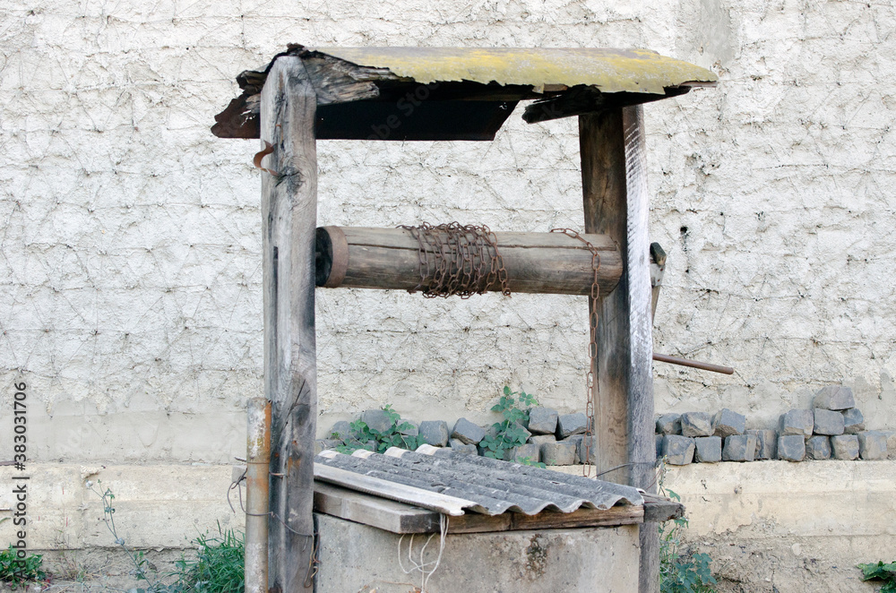 Old well on the background of the wall. Old well on the background of the wall.