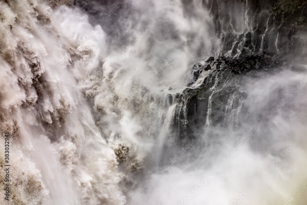 Abstract scene of spectacular Dettifoss waterfall in Iceland after floods filled with muddy water and rocks in background