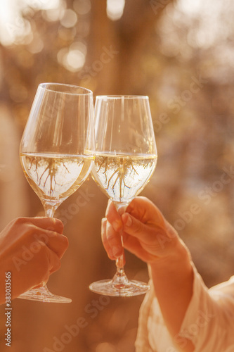 Two glasses of white wine in hands