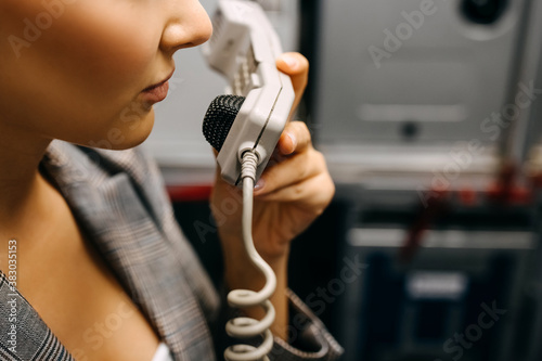 Stampa su tela Stewardess talking on phone in the airplane, closeup.