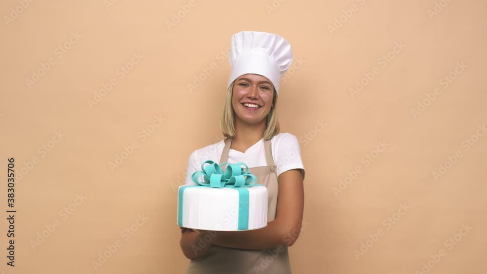 Young cook woman holding a cake laughing and having fun Young cook woman holding a cake laughing and having fun