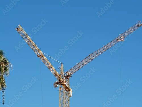 Tower cranes formed aletter V blue sky