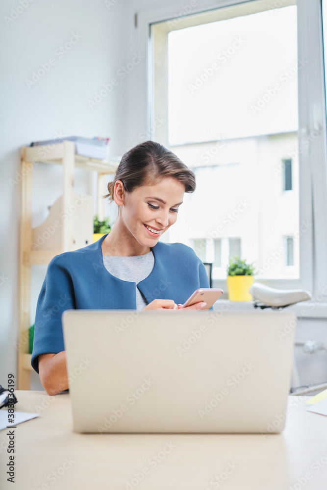 Businesswoman using phone while working from home office Businesswoman using phone while working from home office