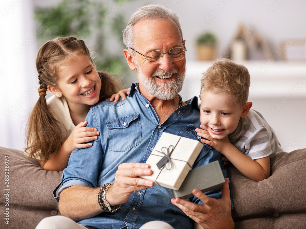 Φωτογραφία Happy family aged grandfather and grandchildren girl   and boy opening gift box