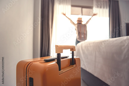 Obraz na plátne Close-up luggage and blurred happy tourist woman background in hotel after check-in