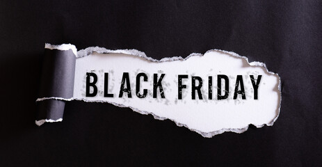 Top view of black torn paper and the text Black Friday on a white background. Black Friday composition.