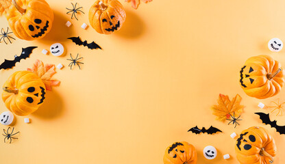 Top view of Halloween crafts, orange pumpkin, white ghost, bat and spider on orange background with copy space for text. halloween concept.