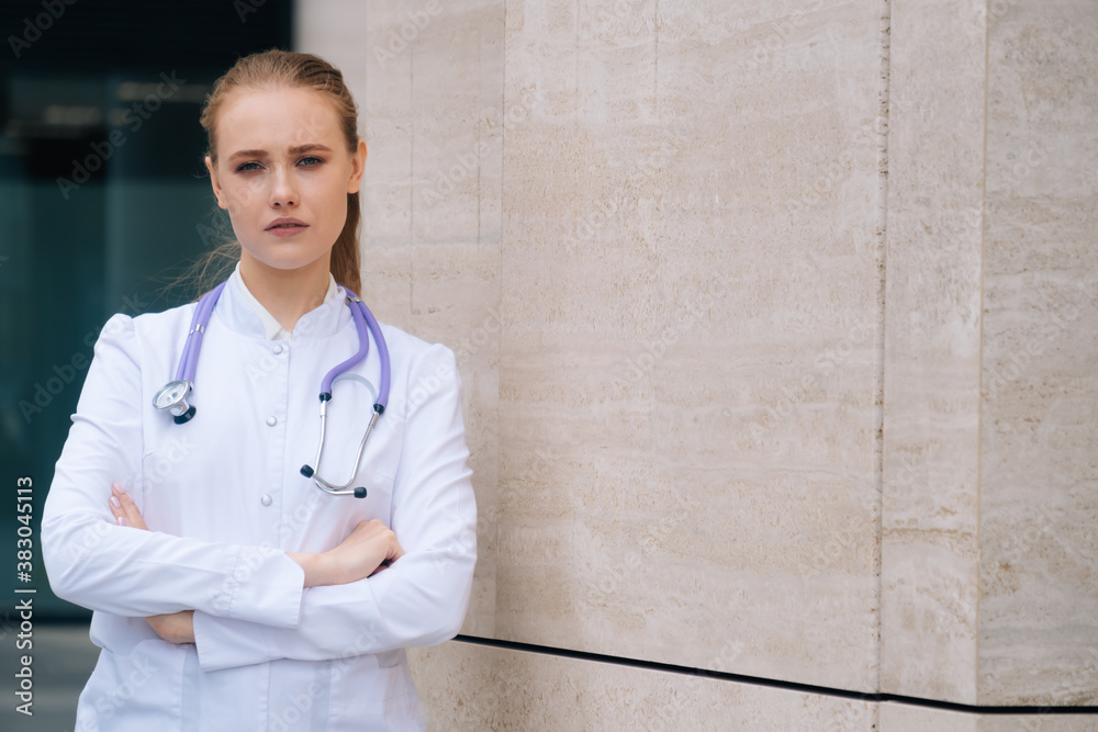 A young beautiful female doctor holds a stethoscope on an isolated white background. A young beautiful female doctor holds a stethoscope on an isolated white background.