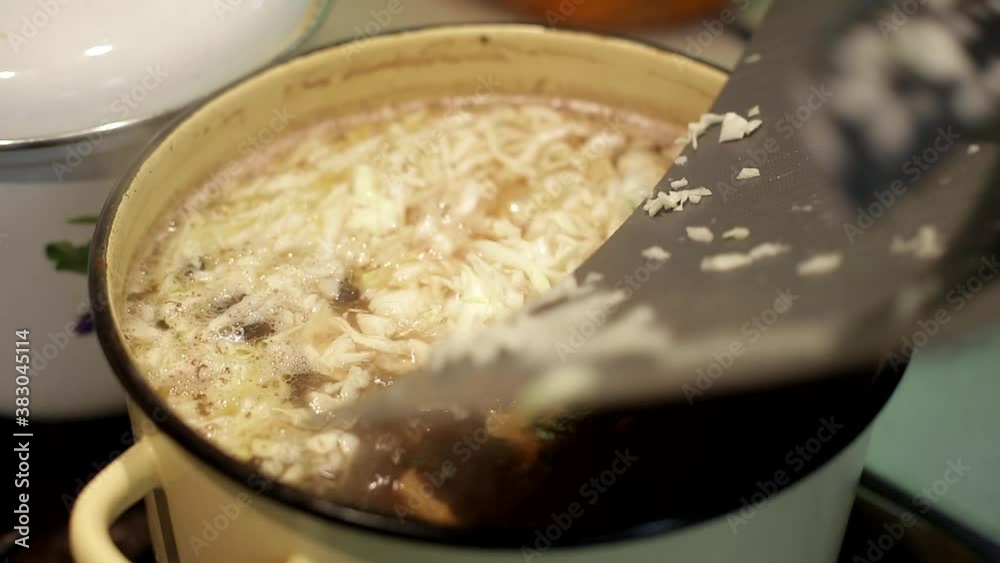 housewife puts shredded cabbage in the soup housewife puts shredded cabbage in the soup