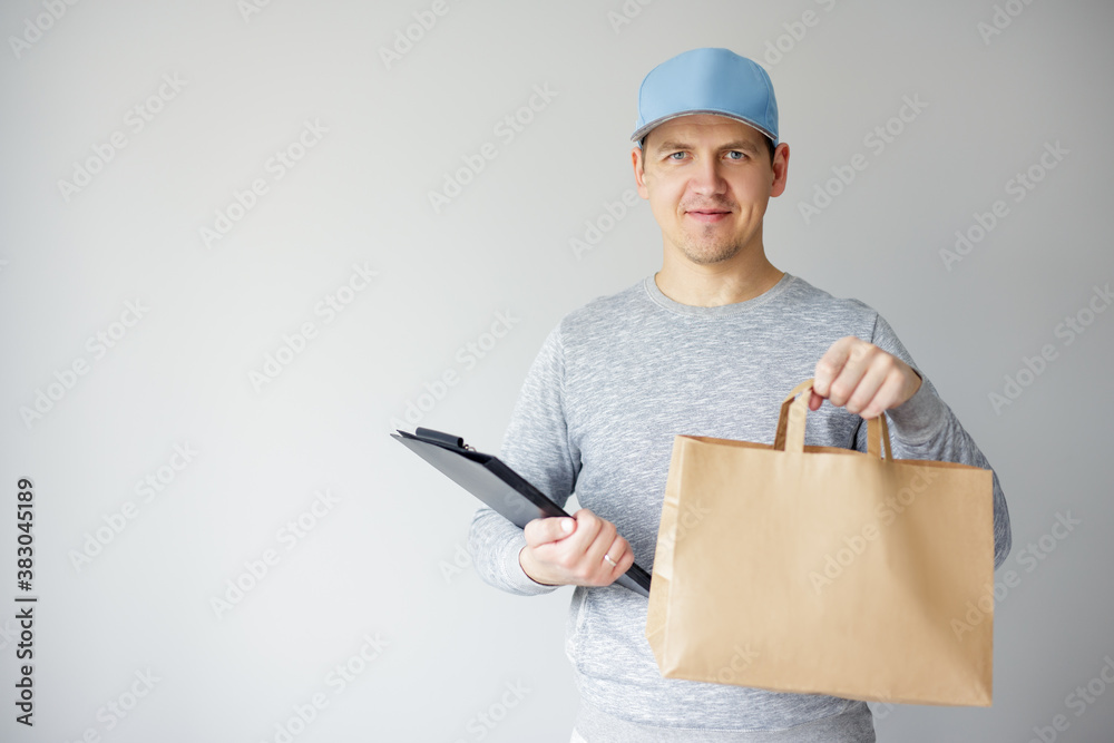 food delivery concept - young delivery man holding paper bag and clipboard over white background food delivery concept - young delivery man holding paper bag and clipboard over white background