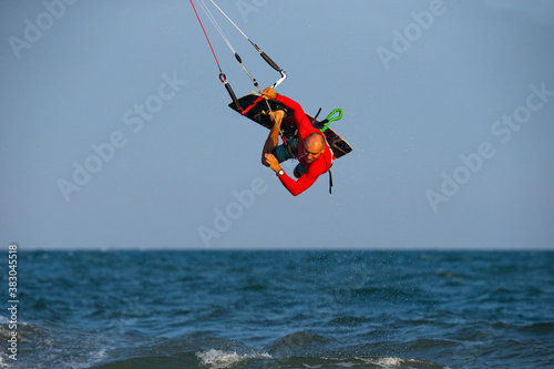 Kitesurfing on the waves of the sea in Mui Ne beach, Phan Thiet, Binh Thuan, Vietnam. Doing the trick - pop