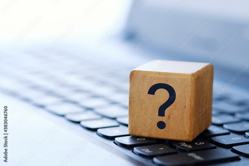 A question mark on a wooden cube on a computer keyboard, with a blurred background and shallow depth of field. - obrazy, fototapety, plakaty 