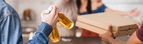 cropped view of multicultural friends holding beer and pizza boxes, website header