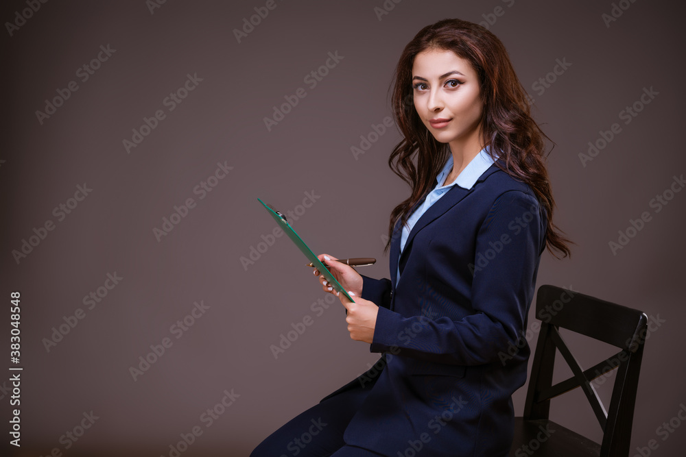 Stylish business woman with a folder in her hands. On dark background Stylish business woman with a folder in her hands. On dark background