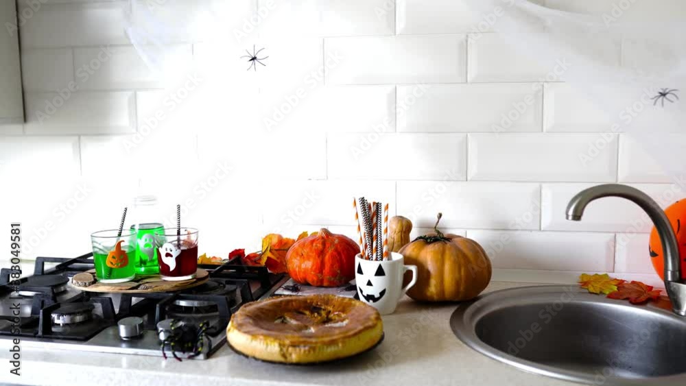 happy Halloween with pumpkin pie and drinks in the kitchen