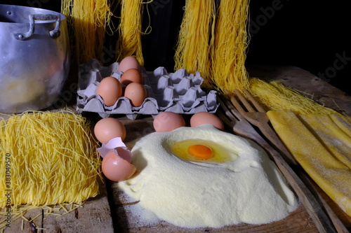 Pasta all'uovo artigianale su sfondo nero e ripiano in legno photo