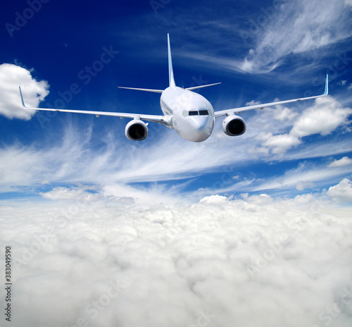 White airplane flying above clouds in the sky