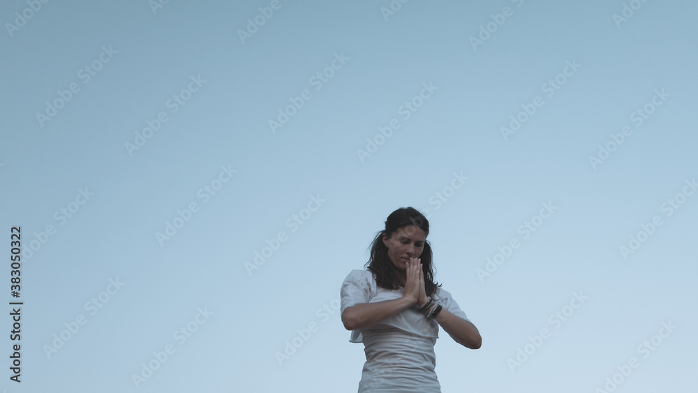 Young caucasian woman brunette doing yoga against blue sky. High quality photo Young caucasian woman brunette doing yoga against blue sky. High quality photo
