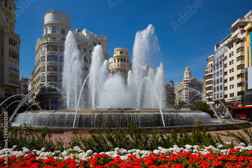 Impressive architecture and large round fountain on Town Hall Square in Valencia on sunny spring day, Spain