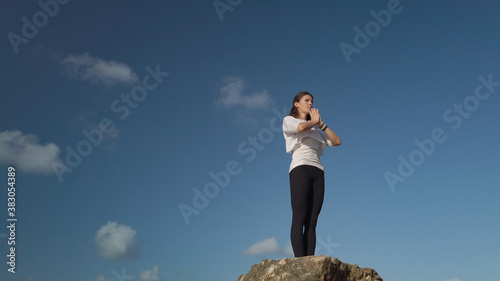 Young caucasian woman brunette doing yoga against blue sky. High quality photo photo