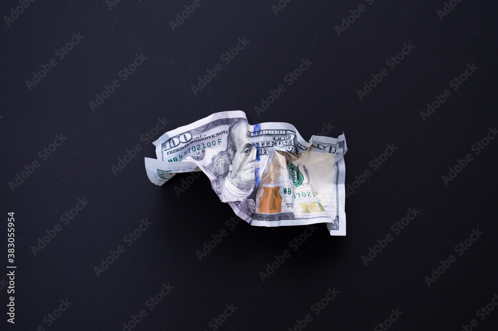 Crumpled one hundred dollar bill on a black background. The concept of the fall of the dollar as a result of the coronovirus pandemic. Copyspace Crumpled one hundred dollar bill on a black background. The concept of the fall of the dollar as a result of the coronovirus pandemic. Copyspace