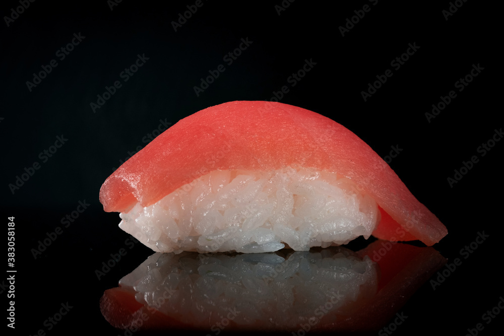 One Japanese fresh Sushi nigiri with tuna on black background, close up One Japanese fresh Sushi nigiri with tuna on black background, close up