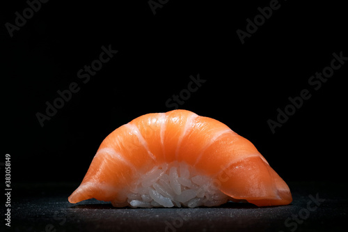 Classic sushi nigiri with salmon on a dark stone background, close up, copy space