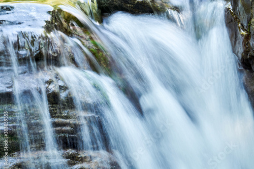 waterfall blurred in motion flows down the rocky ledges  close-up