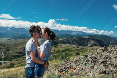 Loving couple together on Altai mountain looking at a view