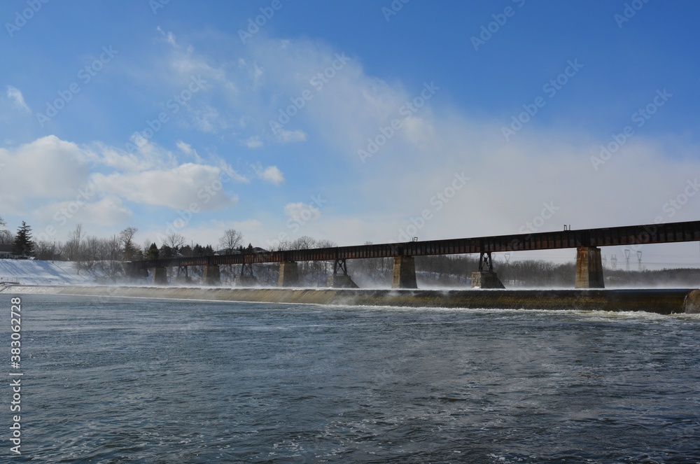 Winter scenery along the Grand River with view of the railroad bridge in Caledonia, Ontario Canada