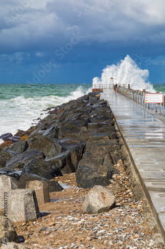 Careless tourist on a pier at the North Sea during heavy weather photo