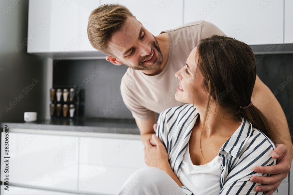 Young beautiful caucasian couple smiling and hugging together at home Young beautiful caucasian couple smiling and hugging together at home