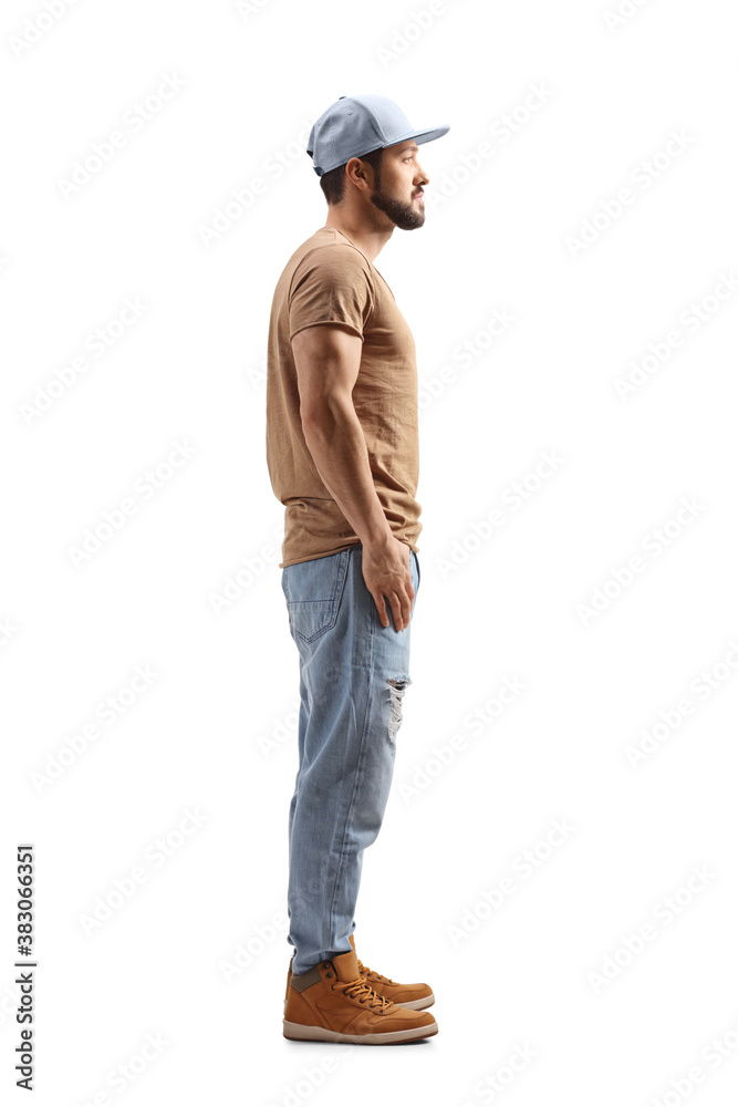 Full length profile shot of a guy with a cap standing Full length profile shot of a guy with a cap standing