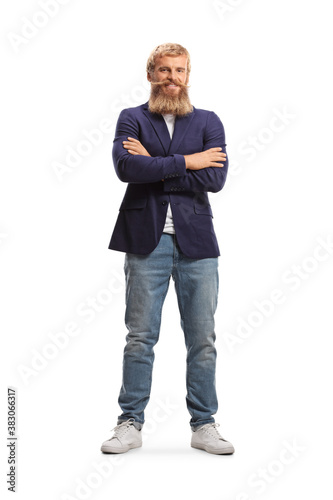 Full length portrait of a guy with blond beard and mustaches wearing jeans and suit