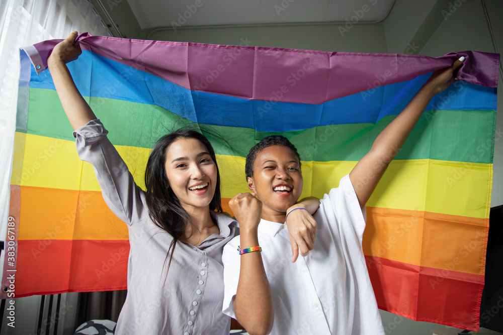 Lgbt Members Black African LGBT woman holding LGBTQ rainbow flag with asian LGBT ...