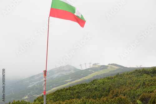 The Bulgarian flag on a hill in the mount of Rila waving in a foggy weather
