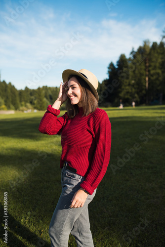 Fényképezés Beautiful young woman in trendy straw hat walking in park sunny day, candid life