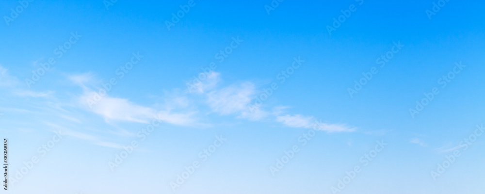Blue sky with stripes of white altocumulus clouds