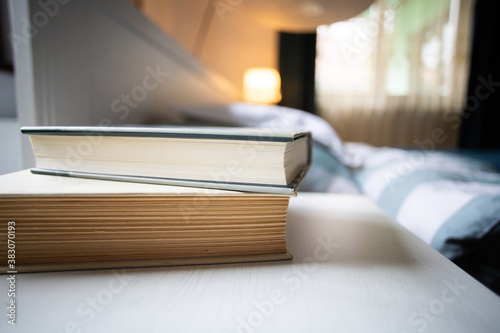 books on bedroom table by bed