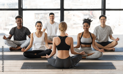 Wellness Concept. Female Yoga Instructor Having Group Lesson With Young Multiracial People