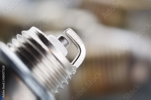 New and used spark plugs for internal combustion engine on metal background. Space for text