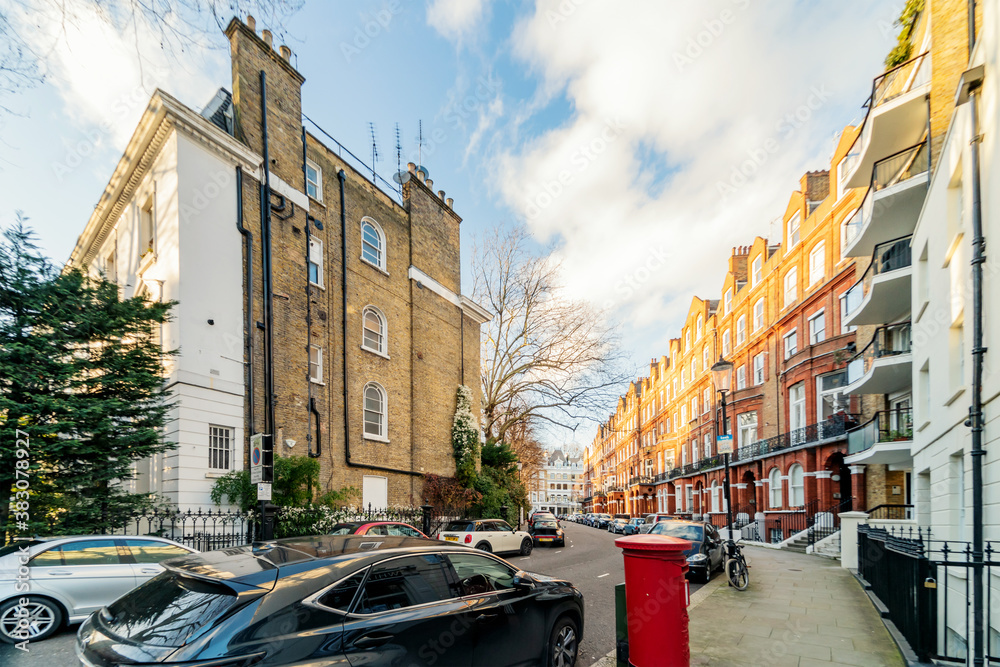 LONDON - MARCH 1, 2020: street with parked cars in traditional residential buildings, blurred background