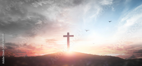 Christian wooden cross on the mountain sunset background