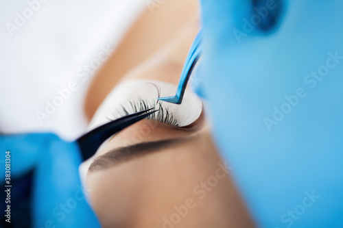 Eyelash Extension Procedure  Professional stylist lengthening female lashes.