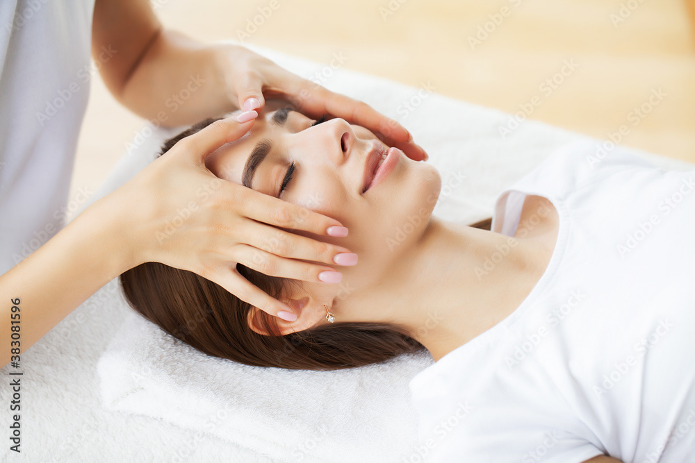Young woman enjoying of facial massage in spa salon Young woman enjoying of facial massage in spa salon