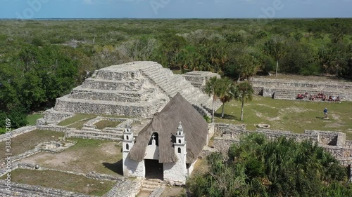 Aerial slider to the left of Xcambo Mayan ruins in Mexico with small Catholic church on the same grounds. photo