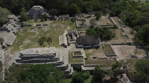 High aerial view with camera pitching down of Xcambo Mayan ruins in Mexico with small Catholic church on the same grounds. photo